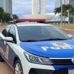 Viatura da Polícia Militar em rua de Brasília, com Congresso Nacional ao fundo, representando estagnação em homicídios no DF.