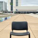 Reunião política em Brasília com Congresso Nacional e cadeiras vazias, expondo divisões na direita.
