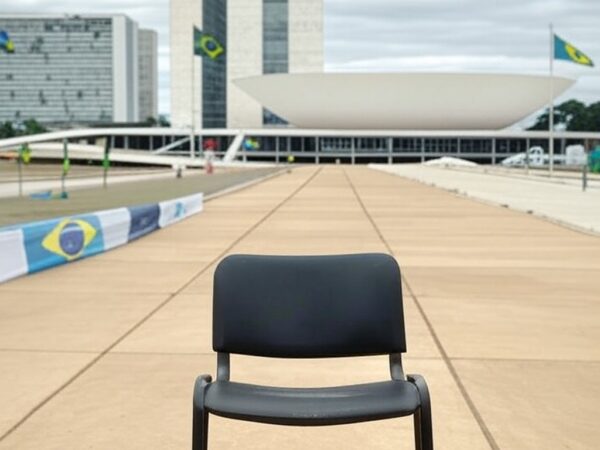 Reunião política em Brasília com Congresso Nacional e cadeiras vazias, expondo divisões na direita.