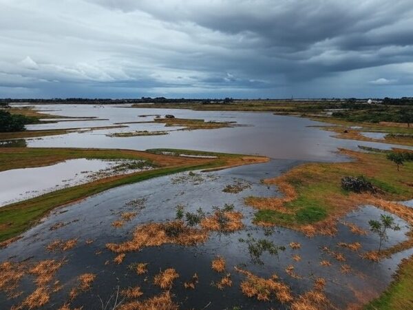 Transbordamento do Reservatório do Descoberto expondo riscos de inundações no Distrito Federal, com água invadindo margens e paisagem do planalto central.