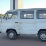 Van escolar irregular em rua de Brasília, com sinalização do Detran-DF e Congresso Nacional ao fundo.