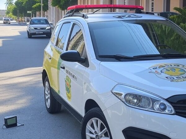 Viatura da polícia em rua de Aracaju, com tornozeleira eletrônica no chão, representando prisão de foragido e falhas no monitoramento.