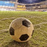 Campo de futebol no Distrito Federal com bola na rede, representando vitória no Candangão.