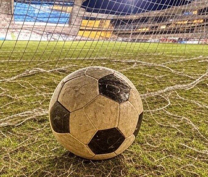 Campo de futebol no Distrito Federal com bola na rede, representando vitória no Candangão.