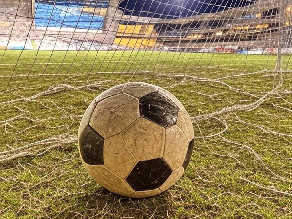 Campo de futebol no Distrito Federal com bola na rede, representando vitória no Candangão.