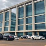 Fachada de hospital em Brasília com viaturas policiais, representando investigação de suspeita de assassinato de pacientes.