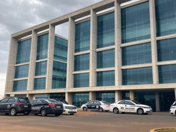 Fachada de hospital em Brasília com viaturas policiais, representando investigação de suspeita de assassinato de pacientes.
