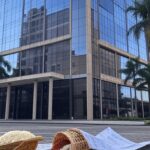 Prédio de banco no Brasil com cesta básica derrubada e documentos rasgados, representando anulação de empréstimos por golpe contra aposentados.