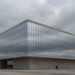 Edifício da CLDF em Brasília com grades danificadas sob chuva, expondo falhas na proteção a mulheres e idosos no DF.