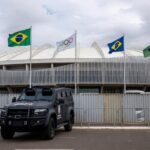 Viatura da polícia do DF perto do Congresso Nacional com elementos de olimpíadas esportivas em meio a crise de segurança.