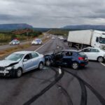 Cena de acidente com quatro veículos na rodovia DF-150 em Sobradinho, Distrito Federal, com viaturas da polícia presentes.