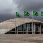 Edifício da CLDF em Brasília com bandeiras, simbolizando Prêmio Marielle Franco e críticas a retrocessos em direitos humanos.