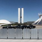 Vista da Esplanada dos Ministérios em Brasília com barreiras de segurança e viaturas policiais, representando ampliação da Área de Segurança Especial.