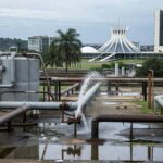 Edifício da Caesb em Brasília com relógio simbolizando prazo curto para seleção de estagiários e críticas por exclusão digital.