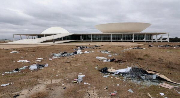 Área ambiental degradada no DF com edifício da CLDF ao fundo, destacando ineficácia em fiscalização.
