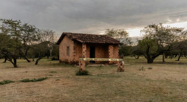 Cena de casa isolada por fita policial em Águas Lindas, Goiás, após tragédia familiar com mortes.