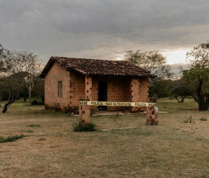 Cena de casa isolada por fita policial em Águas Lindas, Goiás, após tragédia familiar com mortes.
