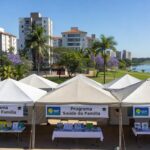 Evento de encerramento do GDF na Sua Porta no Paranoá, com tendas e banners de serviços essenciais para a comunidade.