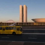 Ônibus do DF em avenida de Brasília com Congresso Nacional ao fundo
