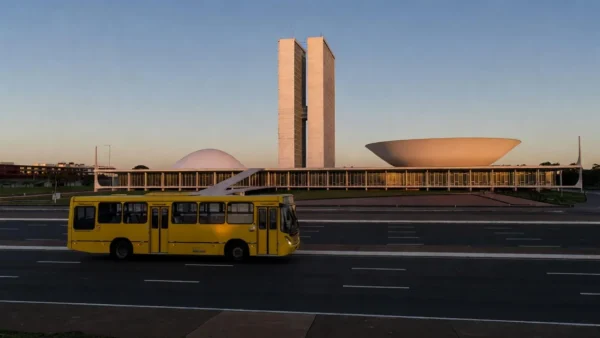 Ônibus do DF em avenida de Brasília com Congresso Nacional ao fundo